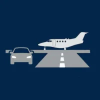 Eine stilisierte Grafik auf dunkelblauem Hintergrund zeigt die graue Silhouette eines Pkw links neben einer grau dargestellten Start- und Landebahn mit weißer Mittellinie. Am Ende der Bahn ist die graue Seitenansicht eines Businessjets platziert. Die flächige Illustration symbolisiert den direkten Zugang zum Flugzeug auf dem Vorfeld und die kurzen Wege bei Finow Air Service.