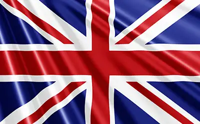 Eine grafische Darstellung der Nationalflagge des Vereinigten Königreichs, bekannt als Union Jack. Die Flagge zeigt die überlagerten Kreuze von England (St. George), Schottland (St. Andrew) und Irland (St. Patrick) in den Farben Blau, Weiß und Rot. Die Grafik ist mit einem detaillierten Faltenwurf und glänzenden Lichtreflexionen gestaltet, die den Effekt einer wehenden Seiden- oder Stofffahne im Wind erzeugen.